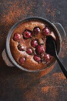 Chocolate and cherry clafoutis, dusted with cocoa powder (top view)