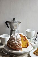 A gugelhupf with currants and icing sugar, sliced