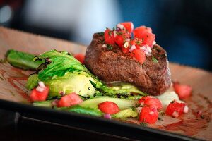 Filet mignon with tomato cubes and salad leaves