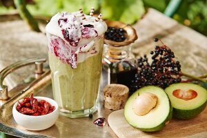 A smoothie with avocado, chili and elderberry frosting on a garden table