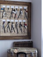 Key hooks in wooden frame lined with old French newspapers