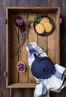 Green tea in a pot and cup, edible flowers, herbs and biscuits in a wooden box