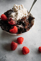 Brownie dump cake with vanilla ice cream and raspberries