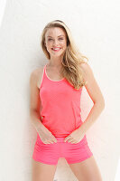 Blonde Frau in rosafarbenem Sporttop und Shorts