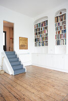 Empty room with fitted cupboards and bookcases in niches