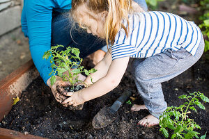 Kleines Mädchen mit Mutter bei der Gartenarbeit