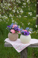 Spring flowers in spherical vases in garden