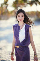 A young brunette woman wearing a purple mini dress