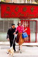 Paar mit Hund vor asiatischem Geschäft