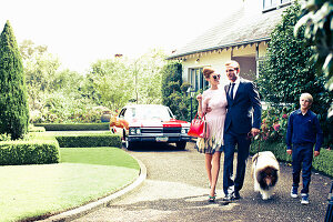 A family of three and a dog going for a walk