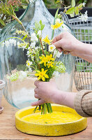 Tying a bouquet of narcissus