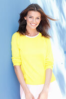A young woman wearing a white dress and yellow jumper