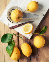 Lemons and lemon leaves on a rustic wooden surface