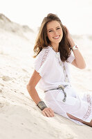 A brunette woman wearing a white summer dress