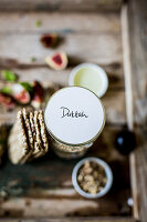 Festive dukkah in a jar as a gift served with low carb seeded crackers, figs, cream cheese and basil