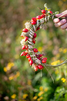 Tying a wreath of rose hips