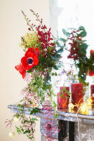 Christmas decoration with anemones, candles and fairy lights on mantelpiece