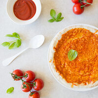 Unbaked pizza with tomato sauce