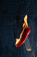A burning chili pepper on a fork