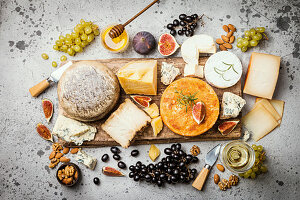 Various types of cheese on wooden cutting board