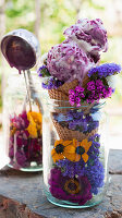 Fruits of the forest ice cream in a cone served with summer flowers in a jar