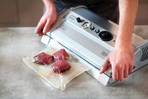 Frozen meat and juices being vacuum packed