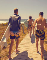 Three young men with surfboards