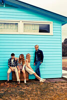 Two couples outside a blue wooden house