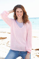 Junge Frau in lila T-Shirt und rosa Pullover