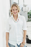 A blonde woman wearing a white shirt blouse