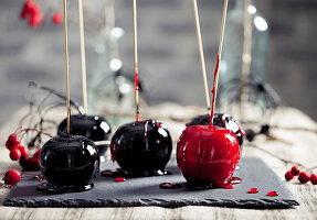 Halloween black and red caramelized apples on a wooden sticks.