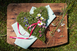 Herzförmiges Gesteck aus Blüten von Leinkraut, Frauenmantel, Majoran und Natterkopf