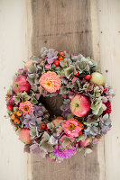 Late-summer wreath of hydrangeas, zinnias and apples