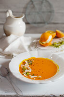 Orange and carrot soup with coconut chips and pistachio nuts