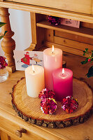 Candles and shiny tin foil balls on a rustic log slice