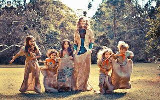 A young woman sack racing with children