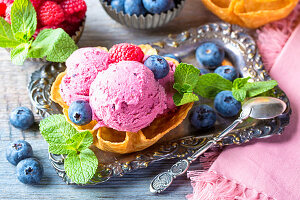 Homemade ice cream with blueberry and raspberries in a wafer bowl