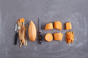 A sweet potato being peeled and julienned