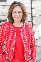 A brunette woman wearing a red top and a red jacket