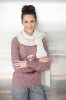 A brunette woman wearing a white scarf with a mottled pink-grey knitted jumper