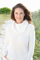 Brunette woman wearing white knit sweater