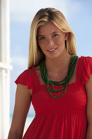Junge blonde Frau im roten Top am Strand