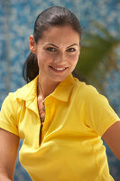 A young brunette woman wearing a yellow polo shirt