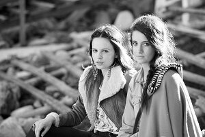 Young women wearing coats looking at the camera