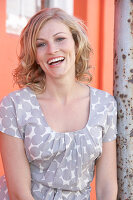 A blonde woman wearing a grey spotted blouse