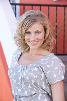 A blonde woman wearing a grey spotted blouse