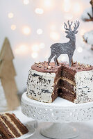Schokoladentorte, angeschnitten und weihnachtlich dekoriert mit silberner Hirschfigur