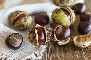 Horse chestnuts with cases on a wooden surface