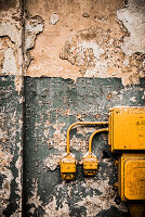 Junction box and power sockets on wall with peeling paint