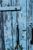 Abgeblätterte blaue Farbe an einer Holztür